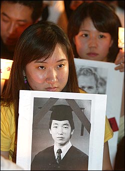 한 집회 참가자가 고 김선일씨의 사진을 들고 촛불집회에 참석하고 있다. 